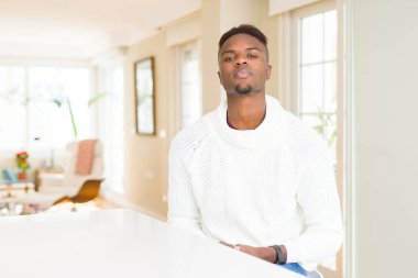 Yakışıklı afro-amerikan adam yüzünde ciddi ifade ile beyaz masada. Kameraya basit ve doğal bir bakış.
