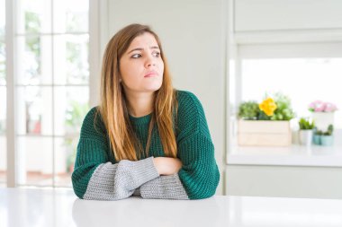 Güzel, iri yarı, sıradan çizgili süveter giyen, kolları çapraz ve kendinden emin genç bir kadın.