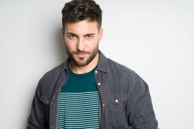 Yakışıklı delikanlı possing ve modelleme gri izole arka plan üzerinde