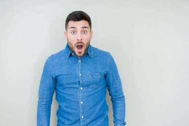 Genç yakışıklı adam korkuyor ve şok sürpriz ifade ile izole arka plan üzerinde korku ve yüz heyecanlı.