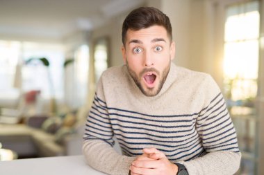 Genç yakışıklı adam evde korkuyor ve sürpriz ifade ile şok korku ve yüz heyecanlı.