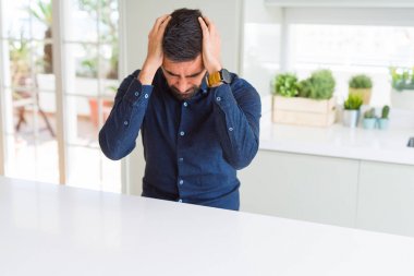 Yakışıklı İspanyol adam baş ağrısı umutsuz muzdarip ve stresli çünkü ağrı ve migren. Eller baş üstünde.