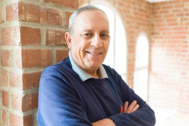 Neşeli, mutlu ve pozitif çapraz kolları olan tuğla duvar arka plan üzerinde gülümseyen yakışıklı orta yaş komuta sizde