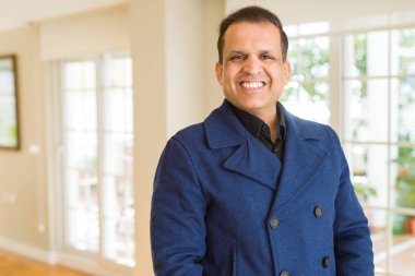 Orta yaş erkek fotoğraf makinesi için evde emin gülümseyen