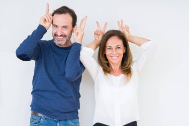 Komik ve çılgın baş parmaklar ile tavşan kulakları, neşeli gülümseyerek poz izole arka plan üzerinde aşık güzel orta yaş kaç