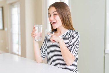 Güzel genç kız çocuk su taze bir bardak içme çok mutlu el ve parmak ile işaret