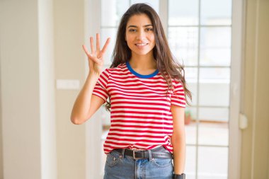 Gösterilen ve parmakları ile işaret rahat t-shirt giyen genç güzel kadın kendinden emin ve mutlu gülümseyerek süre dört numara.