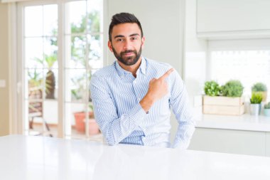 Yakışıklı İspanyol iş adamı yan reklam gösteren el parmağı ile işaret, ciddi ve sakin yüzü