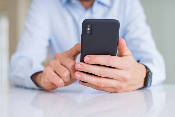 Fechar as mãos do homem usando smartphone e sorrindo — Fotografia de Stock