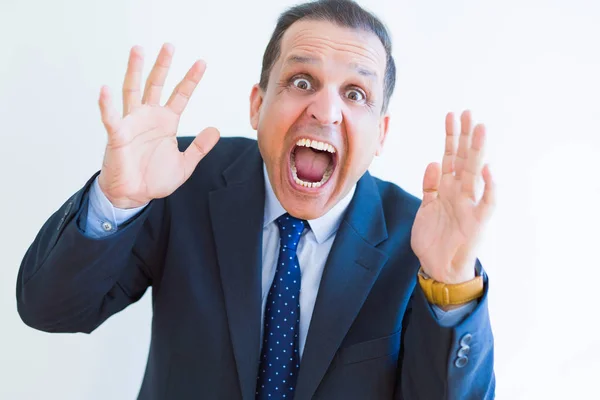 Middle age man shouting crazy with hands over mouth over white w — Stock Photo, Image