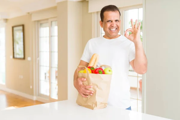 Homem Meia Idade Segurando Mantimentos Saco Compras Casa Fazendo Sinal — Fotografia de Stock