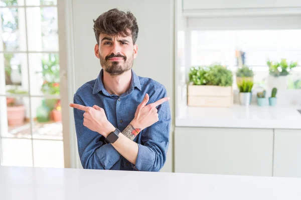 Hombre Joven Con Camisa Casual Sentado Mesa Blanca Señalando Ambos —  Fotos de Stock