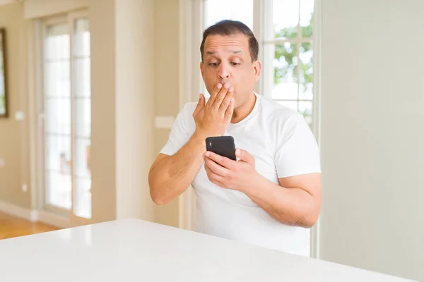 Hombre Mediana Edad Utilizando Teléfono Inteligente Boca Cubierta Casa Con —  Fotos de Stock