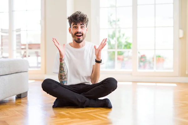 Jonge Man Werkt Zittend Casual Vloer Thuis Vieren Gek Verbaasd — Stockfoto