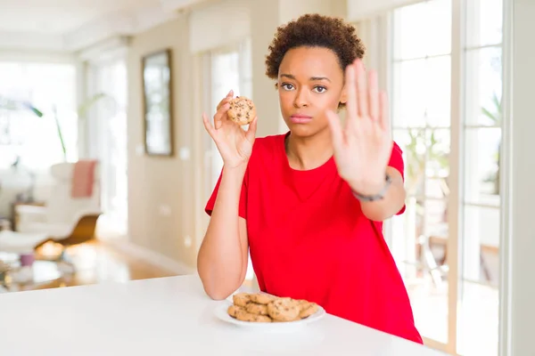 Unga Afroamerikanska Kvinnan Äter Chips Choklad Cookies Med Öppna Hand — Stockfoto