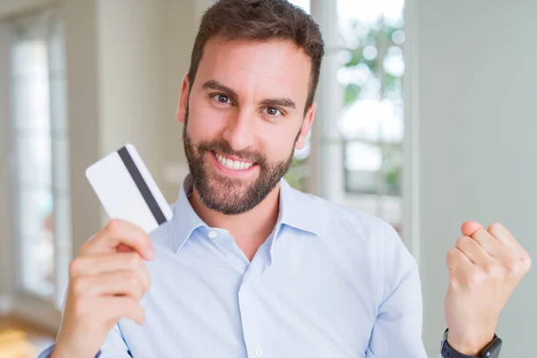 Hombre Negocios Guapo Sosteniendo Tarjeta Crédito Gritando Orgulloso Celebrando Victoria —  Fotos de Stock