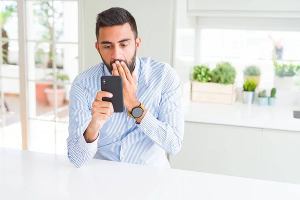 Schöner Hispanischer Geschäftsmann Mit Smartphone Deckel Mund Mit Hand Schockiert — Stockfoto