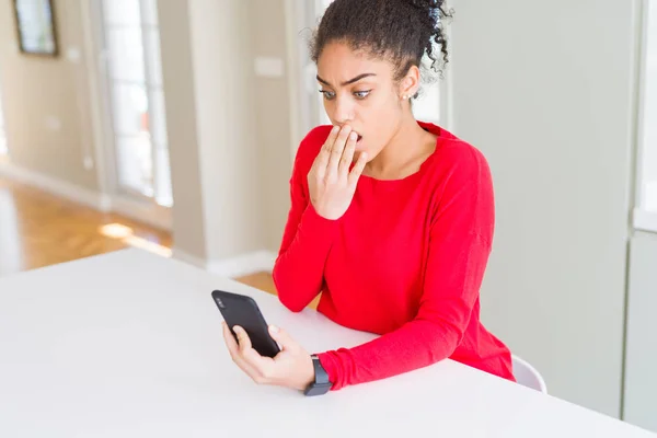 年轻的非洲裔美国妇女使用智能手机发短信封面嘴与手震惊的错误 表达恐惧 害怕在沉默中 秘密的概念 — 图库照片