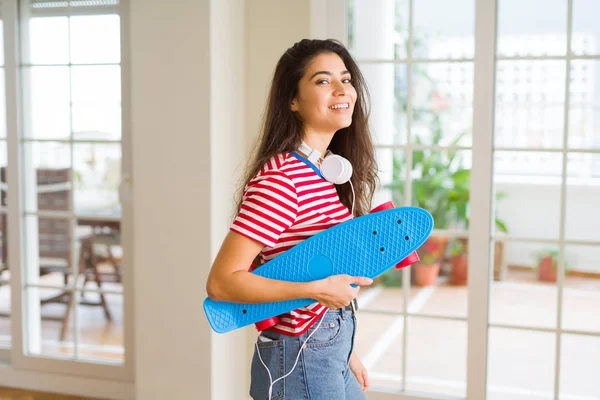 Hermosa mujer skater sonriendo amistoso de pie con monopatín — Foto de Stock