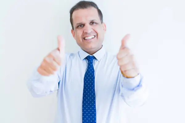 Hombre de mediana edad haciendo gesto postive con los pulgares hacia arriba sonriendo a t — Foto de Stock