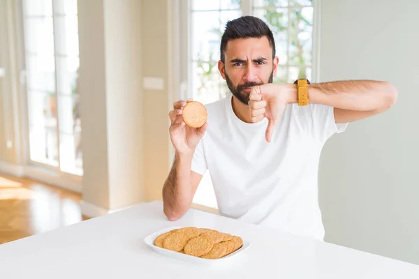 Όμορφος Ισπανικός Άνθρωπος Που Τρώει Υγιή Ολόκληρα Μπισκότα Κόκκων Θυμωμένο — Φωτογραφία Αρχείου
