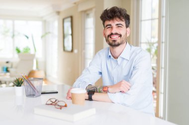 Genç iş adamı yüz üzerinde mutlu ve serin bir gülümseme ile çalışıyor. Şanslı kişi.