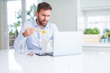 İş adam yeme Asya erişte yemek sırasında çalışma u götürün