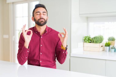 Yakışıklı İspanyol iş adamı rahatla ve gülümseyen gözlerle parmak ile meditasyon jest yapıyor kapalı. Yoga kavramı.