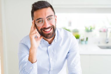Gözlük takan ve neşeli gülümseyen yakışıklı iş adamı 