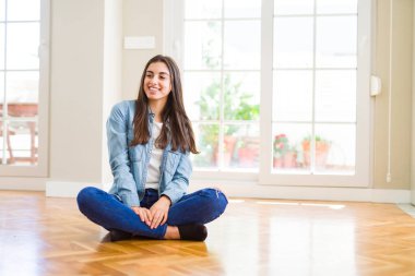 Ev uzak tarafına gülümseme ile yüzünde, doğal ifade arıyorum, yerde oturan güzel genç kadın. Kendine güvenen gülüyor.