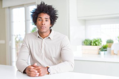 Evde Afro-Amerikan adam yüzünde ciddi ifade ile rahat. Kameraya basit ve doğal bir bakış.