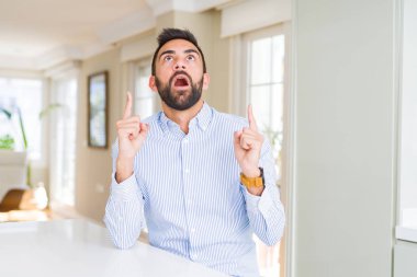 Yakışıklı İspanyol iş adamı şaşırtmak ve yukarıya bakıp parmakları ile işaret şaşırttı ve silah kaldırdı.