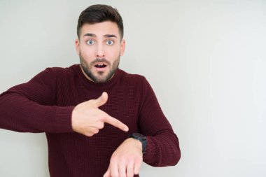 Acele işaretleme izlemek için zaman, sabırsızlık, üzgün ve kızgın son tarih gecikme için izole arka plan üzerinde bir kazak giyen genç yakışıklı adam