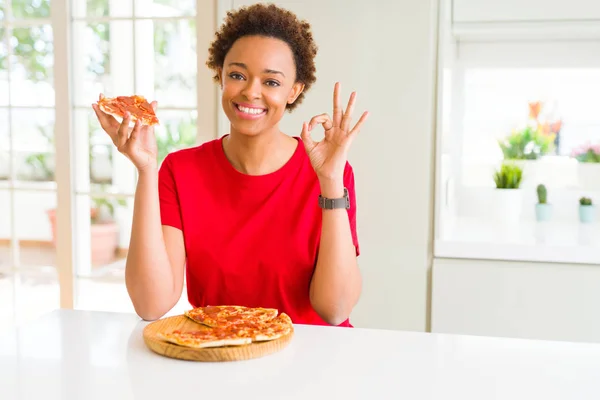 Joven Mujer Afroamericana Comiendo Sabrosa Pizza Peperoni Haciendo Signo Con —  Fotos de Stock