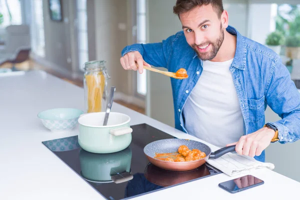Handsome man cooking pasta at home — Stock Photo, Image