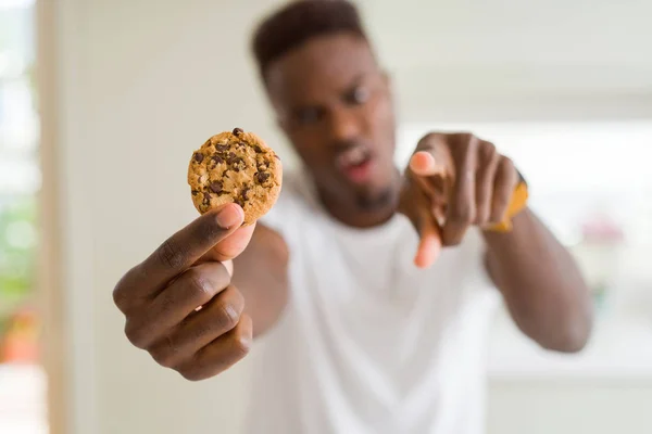 Νεαρός Αφρικανική Αμερικανική Άνθρωπος Που Τρώει Σοκολάτα Τσιπ Cookies Δείχνοντας — Φωτογραφία Αρχείου