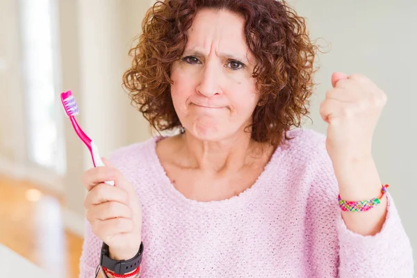 Mulher Sênior Segurando Escova Dentes Rosa Clínica Dental Irritado Frustrado — Fotografia de Stock
