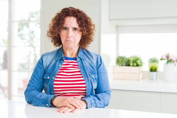 Evde kot ceket giyen kıvırcık saçlı orta yaş yaşlı kadın depresif ve sıkıntı için endişe, kızgın ve korkmuş ağlıyor. Hüzünlü ifade.