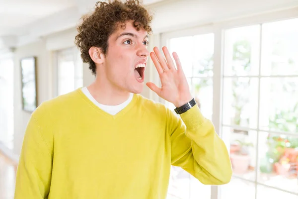 Joven Hombre Guapo Con Suéter Amarillo Casa Gritando Gritando Fuerte —  Fotos de Stock