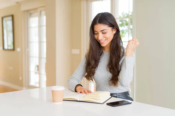 Mujer Joven Leyendo Libro Bebiendo Café Gritando Orgulloso Celebrando Victoria —  Fotos de Stock