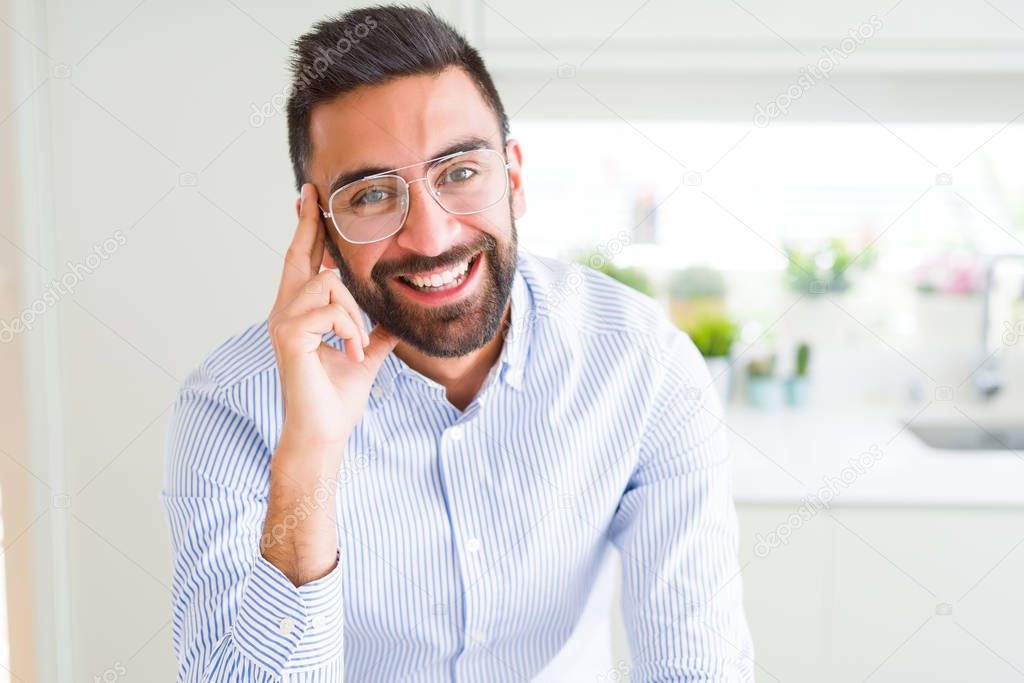 Handsome business man wearing glasses and smiling cheerful with 