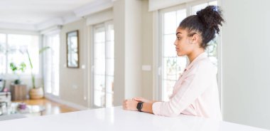 Afro saç ile güzel Afrikalı Amerikan kadın geniş açı yan arıyor, doğal yüz ve emin gülümseme ile profil poz rahatlayın.