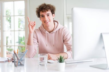 Bilgisayar kullanan genç öğrenci bir fikir ya da mutlu yüz ile işaret parmağı ile sürpriz, bir numara