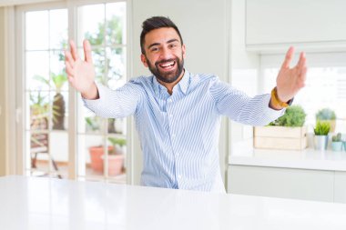 Yakışıklı İspanyol iş adamı sarılmak için açık kollar ile gülümseyen kamera bakıyor. Mutluluğu kucaklayan neşeli ifade.