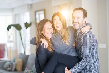 Güzel aile birlikte. Anne, baba ve kızı gülümseyen ve evde sevgi ile sarılma.