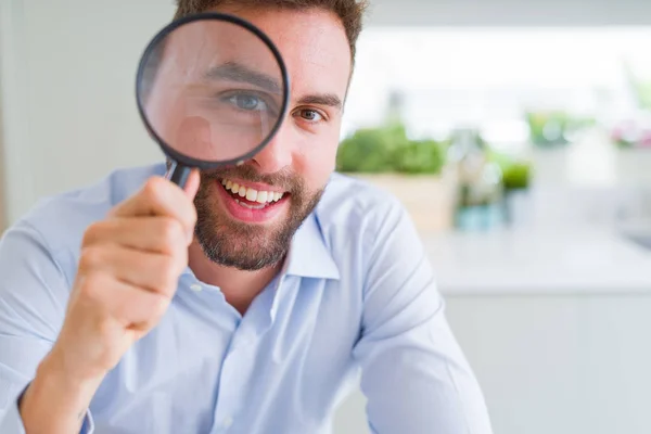 Schöner Geschäftsmann mit Lupe nah am Gesicht, bi — Stockfoto