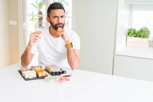 Przystojny Mężczyzna Hiszpanin Jedzenie Sushi Azjatycki Pomocą Pałeczki Poważny Wyraz — Zdjęcie stockowe