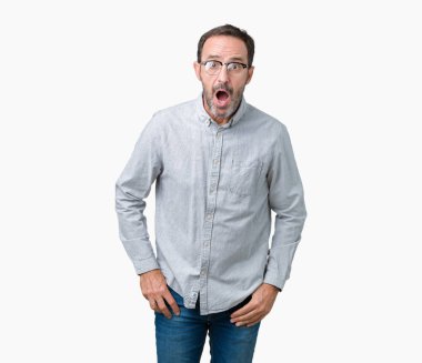 Korkuyor ve şok sürpriz ifade, korku ve heyecan yüz ile izole arka plan üzerinde gözlük takan yakışıklı orta yaş zarif komuta sizde.