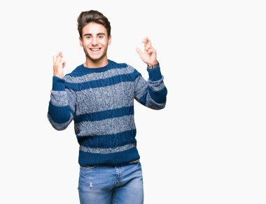 Yakışıklı delikanlı geçiş parmakları umut ve gözleri kapalı ile gülümseyen izole arka plan üzerinde. Şans ve batıl kavramı.