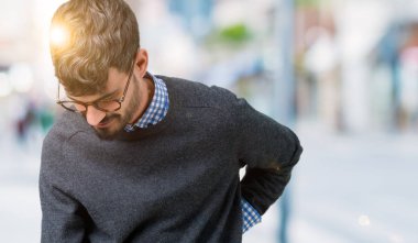 Genç yakışıklı zeki adam gözlük izole üzerinde el ile geri, kas ağrısı dokunmadan acı sırt ağrısı, arka plan